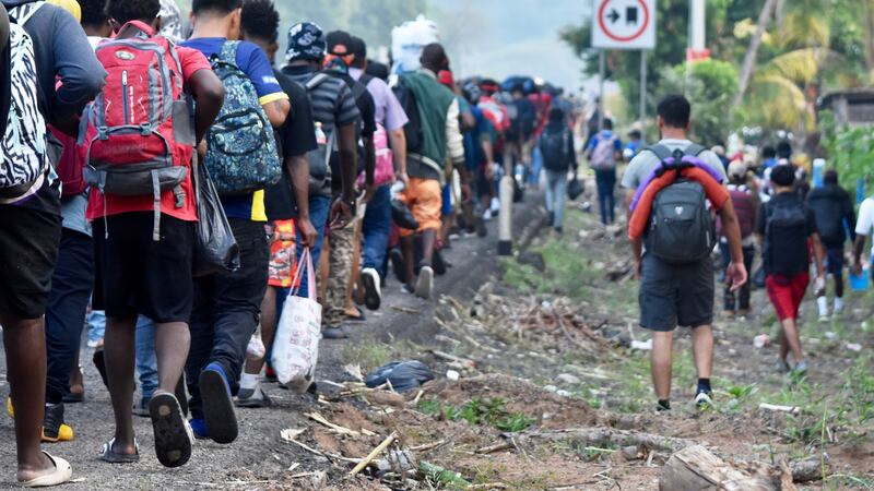 Migrantes caminan por la carretera que atraviesa el municipio de Huehuetán, estado de Chiapas,...